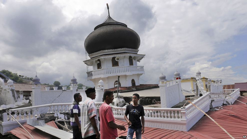 Warga memeriksa sebuah masjid yang amblas karena gempa di Pidie Jaya, Aceh (7/12). (AP/Heri Juanda)