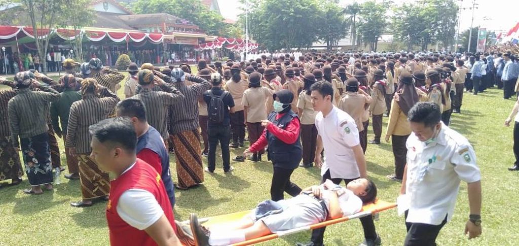 seorang siswi peserta Apel HUT RI ke-74 di halaman kantor Bupati Sanggau terpaksa ditandu dan bibawa ke posko kesehatan Apel HUT RI Pemda Sanggau Terpaksa Ditandu