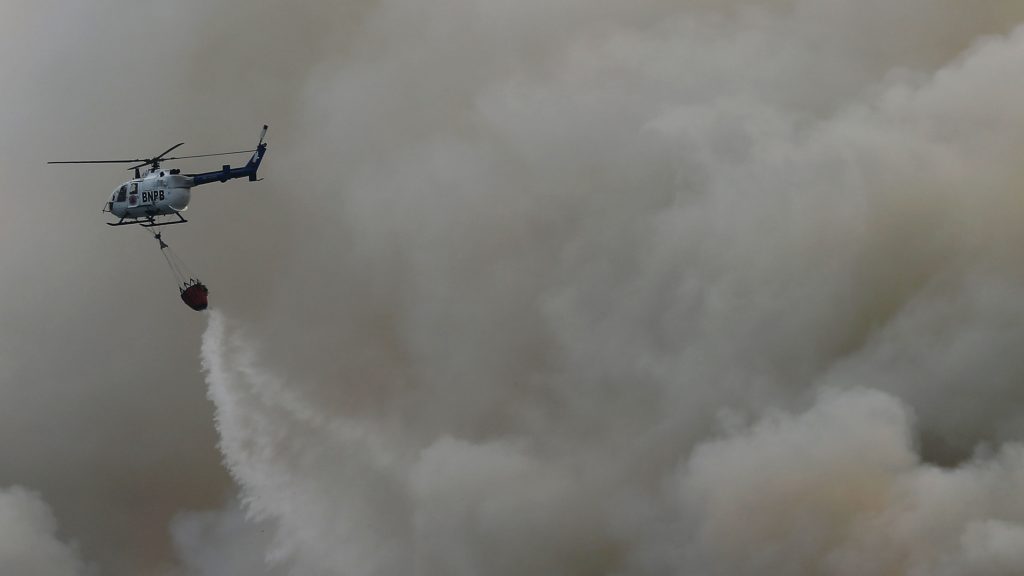 Sebuah helikopter berusaha memadamkan kebakaran lahan di Indralaya, Kabupaten Ogan Ilir, Sumatera Selatan, Rabu (5/11). Hingga saat ini terdapat 194 titik api (hotspot) yang tersebar di Provinsi Sumatera Selatan. ANTARA FOTO/Rosa Panggabean/ed/ama/14.