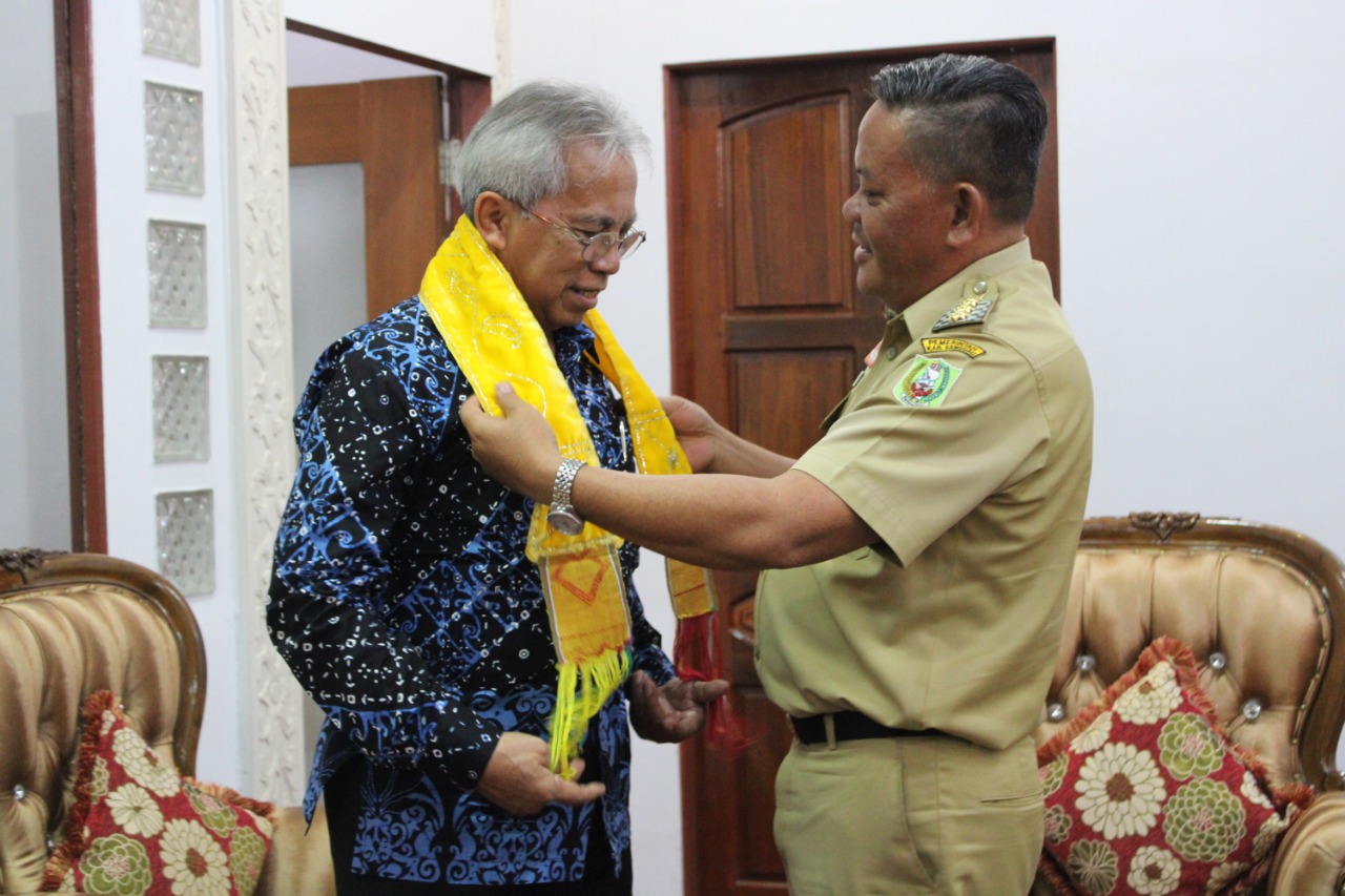 Foto—Bupati Paolus Hadi memberikan cinderamata kepada Rektor Unitri Malang, Eko Handayanto