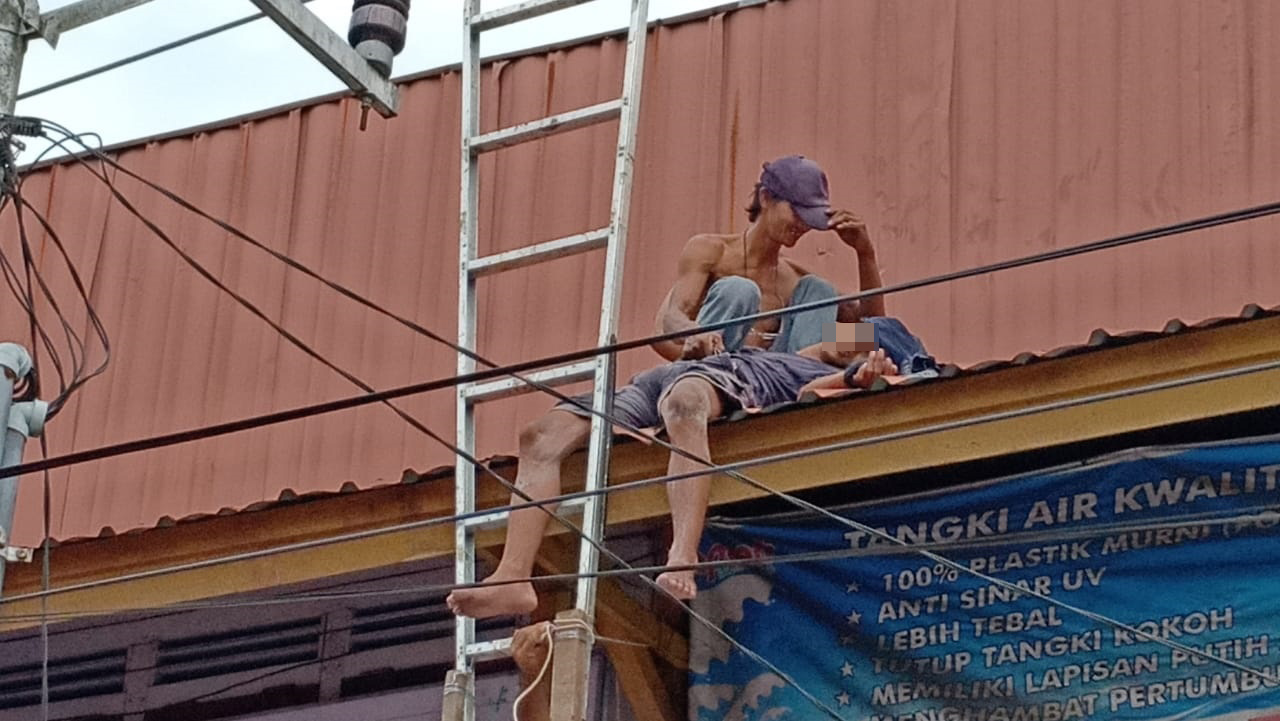 Foto---Petugas UPK Pemkab Sanggau bersama Kapolsek Kapuas AKP Sri Mulyono dibantu warga saat menurunkan korban tersengat listrik.---ist